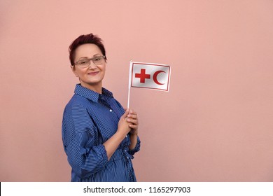 Helsinki, Finland - June 07 2018: IFRC International Federation Of Red Cross And Red Crescent Societies Flag. Woman Holding Red Cross Flag. Editorial Use Only.