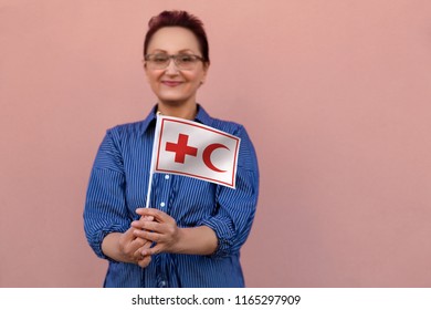 Helsinki, Finland - June 07 2018: IFRC International Federation Of Red Cross And Red Crescent Societies Flag. Woman Holding Red Cross Flag. Editorial Use Only.