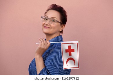 Helsinki, Finland - June 07 2018: IFRC International Federation Of Red Cross And Red Crescent Societies Flag. Woman Holding Red Cross Flag. Editorial Use Only.