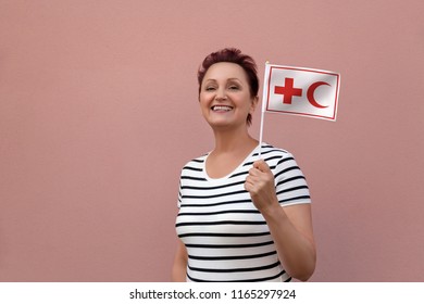 Helsinki, Finland - June 07 2018: IFRC International Federation Of Red Cross And Red Crescent Societies Flag. Woman Holding Red Cross Flag. Editorial Use Only.