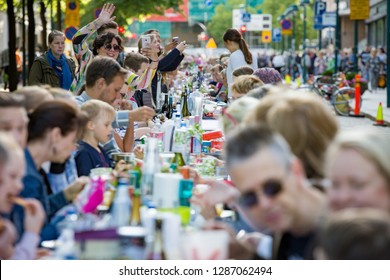 Helsinki, FINLAND - JUNE 12, 2018: Long Table With Lots Of People Eating And Drinking Together. The Day Of City Celebration In Centre Of Helsinki. Finnish Your Dinner Under The Sky.