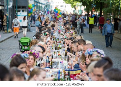 Helsinki, FINLAND - JUNE 12, 2018: Long Table With Lots Of People Eating And Drinking Together. The Day Of City Celebration In Centre Of Helsinki. Finnish Your Dinner Under The Sky.