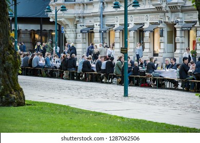 Helsinki, FINLAND - JUNE 12, 2018: Long Table With Lots Of People Eating And Drinking Together. The Day Of City Celebration In Centre Of Helsinki. Finnish Your Dinner Under The Sky.