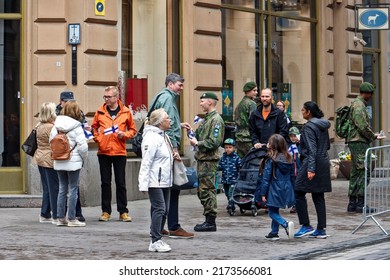 HELSINKI, FINLAND - JUNE 4, 2022:
Defense Forces Flag Day in Helsinki. The viewing of the troops was held at Senatintor in the heart of Helsinki. Soldiers give small Finnish flags to people.