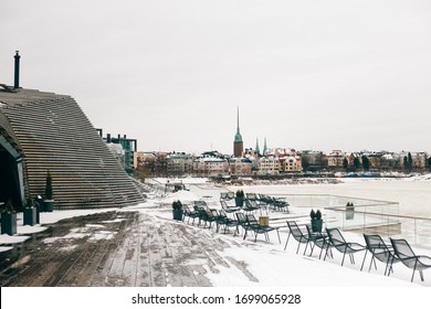 Helsinki / Finland - March, 8th, 2017.
Canned Idle Restaurant Terrace With Iew Of The Frozen Sea And Cityscape. Everything Is Covered With Snow. Depression, Hibernation, Business Closure.