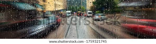 Helsinki, Finland. Riding tram\
in the city center of Helsinki the capital of Finland. Car and tram\
traffic. Cloudy rainy day, many shops, cafes. Rain drops on the\
window