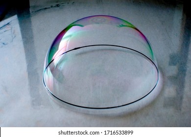 A hemisphere soap bubble stands on the surface
