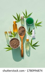 hemp cosmetic products glass bottles with oil, Hemp seed extract, cream and hemp seeds and leaves on a mint  background. Flat lay