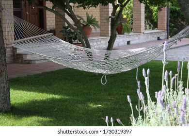 Hemp hammock in an empty garden in the shade of the trees.