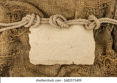 Hemp Rope With Vintage Torn Paper On Burlap Background. Close-up Of A Natural Rope And Fabric. Put Your Own Text Here