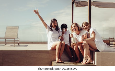 Hen party on the rooftop. Bride and bridesmaids having champagne and laughing. Girls are going crazy before wedding. - Powered by Shutterstock