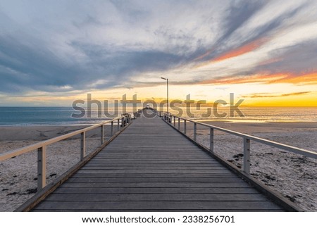 Henley Beach pier at sunset with the tranquil sea and clouds above, South Australia