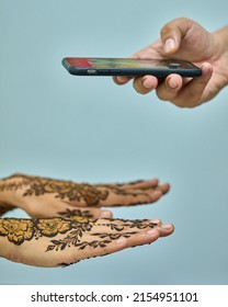 Henna Art (Mehndi Hand-painting). Painted Hands With Mobile Phone.       