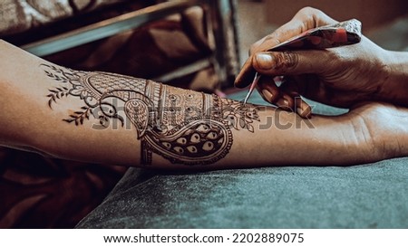 Henna tattoo apply on a bride hands. Elegant Brown Colors of Henna Ink. Indian Traitional Mehendi Ceremony.