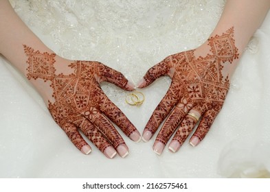 Henna tattoo on the bride's hand. Heart shaped hand. With a wedding ring in the middle - Shutterstock ID 2162575461
