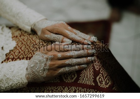 henna is a traditional ritual in Indonesia where the bride will decorate the palms of her hands or legs before the marriage contract
