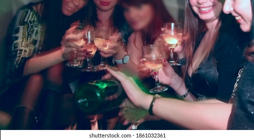 Hen-party. Woman Pours Champagne Into Glasses For Girlfriends. Female Sit At The Car And Drink Champagne Together. Bachelorette Party. No Faces.