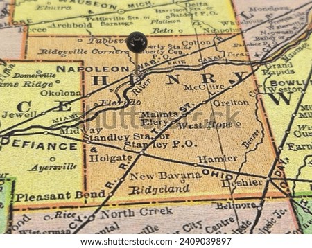 Henry County, Ohio marked by a black tack on a colorful vintage map. The county seat is located in the city of Napoleon, OH.