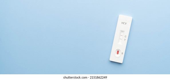 Hepatitis C Virus Antibody Test Kit With Positive Result On Blue Background. Screening For Hepatitis C Uses A Blood Sample, Collected From A Finger Prick. World Hepatitis Day.