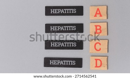 Hepatitis types a b c and d are represented by wooden tiles next to corresponding letter blocks illustrating the classification of this serious liver disease for medical education or public health.