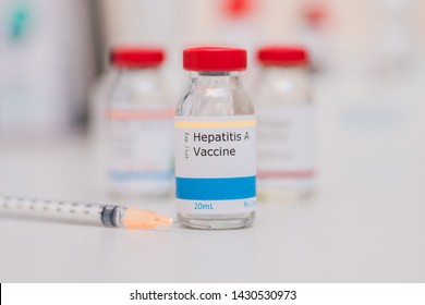 Hepatitis A Vaccine Concept With Other Vaccination Vials In Background And Syringe In Foreground