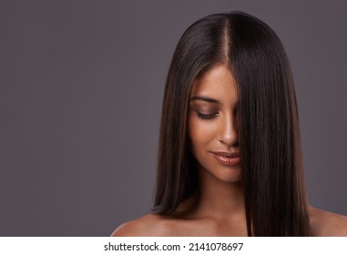 Its Her Crowning Glory. A Young Woman With Sleek Hair Posing In Studio.