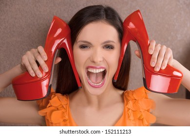 Her Favourite Shoes. Excited Young Woman Holding Red Heeled Shoes Near Face And Shouting