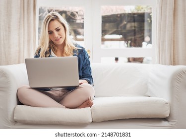 Its Her Favourite Spot To Browse. Shot Of A Young Couple Browsing On A Laptop At Home.