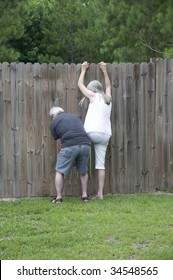 Her husband helps her peek over the fence to see what the neighbors are up to!