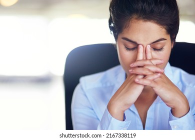 Her job can get quite hectic at times. Shot of a young businesswoman looking stressed while sitting in her office chair.