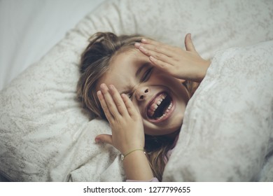 Her morning starts with a smile. Little girl lying on bed. Close up. - Shutterstock ID 1277799655