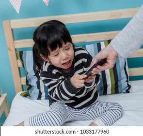 Her Mother Hold The Phone With A Crying Child, Baby Healthy And Preschool Concept