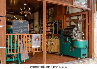 Heraklion, Crete, Greece - Mar 23, 2019: Coffee Shop At The Traditional Central Market In Heraklion City. Old Coffee Roaster Machine. Traditional Cretan Products, Herbs, Raki, Spices, Candies For Sell