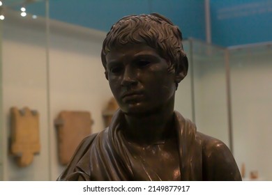 Heraklion, Greece - July, 03, 2021: Head of a bronze statue of a young man wrapped in a mantle. The eyes were inlaid with a different material. High artistic quality of the Late Hellenistic period