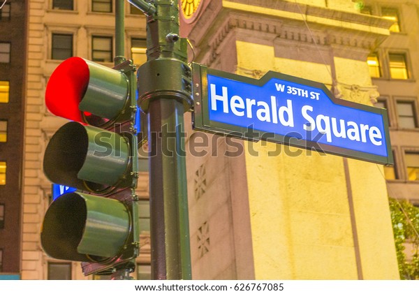 Herald Square street sign and traffic light in
Manhattan at night.