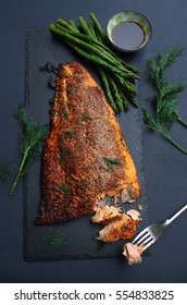 herb roasted salmon fillet with asparagus on dark background. selective focus