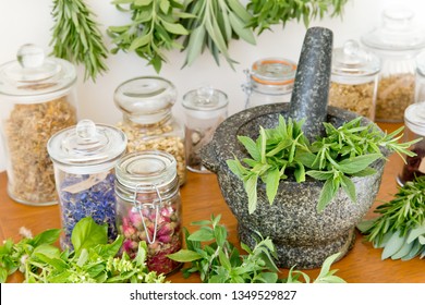 Herbal Apothecary jars, fresh and dried herbs and stone mortar and pestle