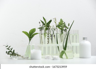 Herbal Cosmetic Products, Laboratory Glassware And Ingredients On White Table