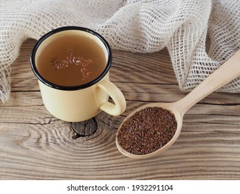 Herbal drink tea and linseed in wooden spoon, napkin on wooden background, top view, flat layout. A useful linum plant with omega and vitamins for use in medicine and vegetarian dietary nutrition
