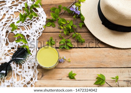 herbal health drinks hot milks green tea with hat ,sunglasses ,knitting wool of lifestyle woman relax summer arrangement flat lay style on background wooden