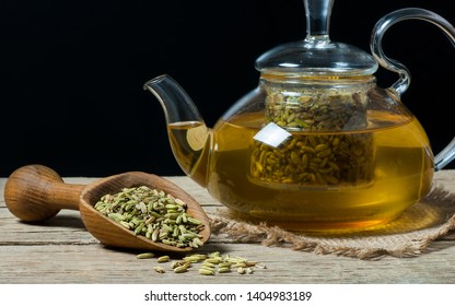 Herbal infusion fennel tea in glass cup  with dried fennel seeds in wooden shovel. Herbal tea alternative medicine background concept.
