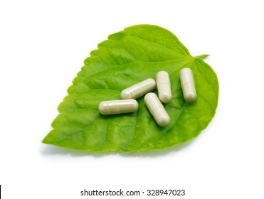 Herbal Medicine Capsules Pills On Green Organic Herb Leaf