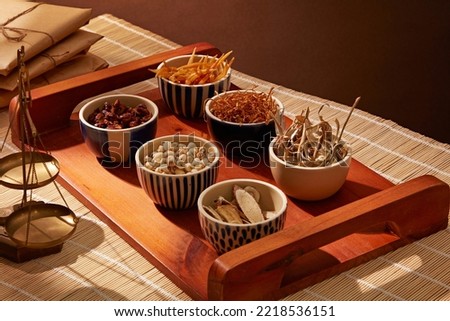 Herbal medicine concept with bowls of dried chopper herbs and spices on the wooden tray.

