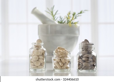 Herbal Medicine Pills And Mortar Over Bright  Background