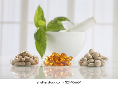 Herbal medicine pills and mortar over bright  background - Shutterstock ID 324406664