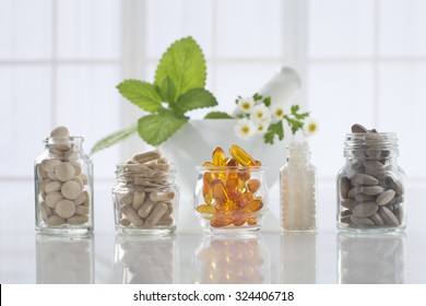 Herbal medicine pills and mortar over bright  background