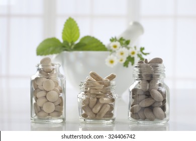 Herbal Medicine Pills And Mortar Over Bright  Background