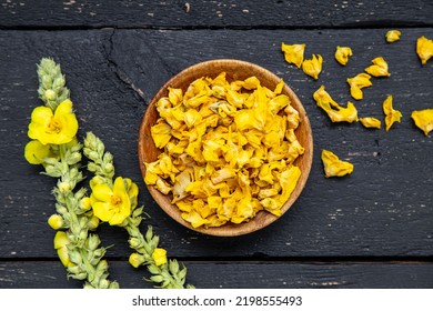 Herbal medicine tea powder made of Verbascum thapsus, the great mullein, greater mullein or common mullein. Yellow dried flower petals on wood bowl. Flat lay view. - Shutterstock ID 2198555493
