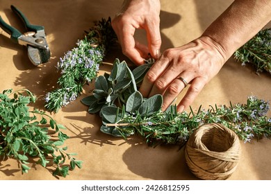 Herbal medicine. Woman's hands preparing sage and others eco friendly medicinal herbs for drying. Herbalist preparing herbs for natural herbal methods of treatment. Alternative medicine. - Powered by Shutterstock