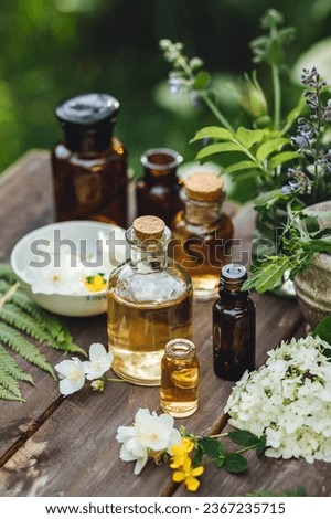 Herbal pure organic essential oil, jasmine, camomile flowers on wooden background. Natural ingredients, apothecary plant-based treatment for relaxation, health care, anti-stress. Aromatherapy